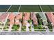 Aerial view of a luxurious Mediterranean-style home with a red tile roof, manicured lawn and waterfront access with docks at 6418 Bright Bay Ct, Apollo Beach, FL 33572
