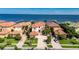 An eye-level view of a luxurious Mediterranean-style home with a red tile roof, and waterfront access with docks at 6418 Bright Bay Ct, Apollo Beach, FL 33572