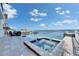 Waterfront pool area featuring a hot tub and an infinity edge, offering stunning views of the ocean and a private dock at 6418 Bright Bay Ct, Apollo Beach, FL 33572