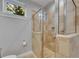 Shower with custom glass doors and travertine tile at 6418 Bright Bay Ct, Apollo Beach, FL 33572