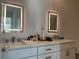Bathroom featuring double sinks with illuminated mirrors and white cabinets at 644 3Rd S Ave # 402, St Petersburg, FL 33701
