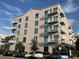 Multi-story building featuring rows of balconies and neutral-colored facade with several parked cars outside at 644 3Rd S Ave # 402, St Petersburg, FL 33701