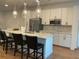 Bright open kitchen featuring white cabinets, island with chairs, stainless appliances and marble backsplash at 644 3Rd S Ave # 402, St Petersburg, FL 33701