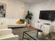 Cozy modern living room with white sofa, accent pillows, glass coffee table and sleek white TV console at 644 3Rd S Ave # 402, St Petersburg, FL 33701