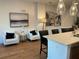 Bright open living room featuring white sofas, island with chairs, and modern art on the walls at 644 3Rd S Ave # 402, St Petersburg, FL 33701