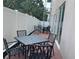 Private outdoor patio with black metal furniture, a brick floor, and a white privacy fence at 644 3Rd S Ave # 402, St Petersburg, FL 33701