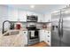 Modern kitchen featuring granite countertops, stainless steel appliances, and white cabinets at 6681 121St Ave # I, Largo, FL 33773