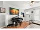 Cozy living room with a piano, large TV, and natural light from a window and a door at 6681 121St Ave # I, Largo, FL 33773