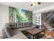 Comfortable living room with a large sectional sofa and a scenic waterfall mural at 6681 121St Ave # I, Largo, FL 33773