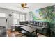Cozy living room featuring wood-look flooring, a ceiling fan, and a scenic mural at 6681 121St Ave # I, Largo, FL 33773