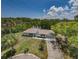 An aerial view showcasing a charming single-story home with lush landscaping and a long driveway at 7332 Janczlik Dr, New Port Richey, FL 34652