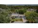 Aerial view of the house surrounded by lush trees and a peaceful pond in a serene setting at 7332 Janczlik Dr, New Port Richey, FL 34652