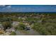 Picturesque aerial view of a neighborhood with lush greenery, a lake, and a glimpse of the ocean in the distance at 7332 Janczlik Dr, New Port Richey, FL 34652