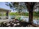 Backyard view of screened-in porch, patio, and lake surrounded by lush trees at 7332 Janczlik Dr, New Port Richey, FL 34652