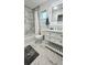 Updated bathroom with modern vanity, marble tile and walk-in shower, providing a fresh and luxurious feel at 7332 Janczlik Dr, New Port Richey, FL 34652