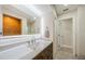 Bathroom with a wooden vanity, white counter, lighted mirror, and tiled shower view at 7332 Janczlik Dr, New Port Richey, FL 34652
