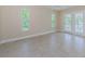 Bright bedroom with tile floors, large windows, and French doors, providing ample natural light and outdoor access at 7332 Janczlik Dr, New Port Richey, FL 34652