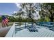 Lakeside deck with blue railing provides serene outdoor space, accentuated by lush greenery and a waving American flag at 7332 Janczlik Dr, New Port Richey, FL 34652