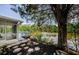 Exterior view of house featuring patio, deck with blue railing, and serene waterfront surrounded by a large tree at 7332 Janczlik Dr, New Port Richey, FL 34652
