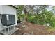 Outdoor view featuring the AC unit, landscaping, and natural backdrop of trees and foliage at 7332 Janczlik Dr, New Port Richey, FL 34652