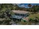 Waterfront home featuring a screened lanai, open deck, and a kayak, perfect for enjoying the water at 7332 Janczlik Dr, New Port Richey, FL 34652