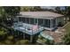 Exterior view showcasing the home's screened in patio and deck, a blue railing, and direct access to the water at 7332 Janczlik Dr, New Port Richey, FL 34652