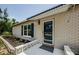 Close-up of a welcoming front porch with a modern door, blue shutters, and fresh landscaping at 7332 Janczlik Dr, New Port Richey, FL 34652