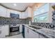 Beautiful kitchen with decorative tile backsplash, granite countertops, stainless steel appliances and a window at 7332 Janczlik Dr, New Port Richey, FL 34652