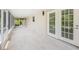 Screened-in patio with access to the rear deck, featuring tile flooring and providing ample natural light at 7332 Janczlik Dr, New Port Richey, FL 34652