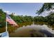 Picturesque waterfront property with an American flag waving and beautiful views of the calm, tree-lined lake at 7332 Janczlik Dr, New Port Richey, FL 34652