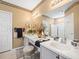Well-lit bathroom with double vanity, large mirror, and decorative accents at 7606 Berna Ln, Land O Lakes, FL 34637