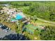 A picturesque aerial view of community pool, lush landscape, and parking area at 7606 Berna Ln, Land O Lakes, FL 34637