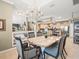 Elegant dining room open to the kitchen with chandelier and striped chairs at 7606 Berna Ln, Land O Lakes, FL 34637