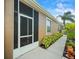 Side view of the house featuring a screened lanai, neat landscaping, and a walkway at 7606 Berna Ln, Land O Lakes, FL 34637