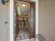 Inviting foyer with decorative rug and front door, leading to the kitchen with barstool seating at 7606 Berna Ln, Land O Lakes, FL 34637