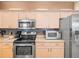 Modern kitchen with stainless appliances, decorative backsplash, and ample storage at 7606 Berna Ln, Land O Lakes, FL 34637