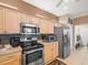 Modern kitchen with stainless appliances, decorative backsplash, and ample storage at 7606 Berna Ln, Land O Lakes, FL 34637