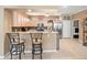 Open kitchen with breakfast bar, stainless appliances, and adjacent laundry room at 7606 Berna Ln, Land O Lakes, FL 34637