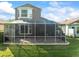 Backyard view featuring a screened lanai and a manicured lawn at 7606 Berna Ln, Land O Lakes, FL 34637