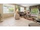 Cozy living room with tile floors, large windows, comfortable seating, and elegant decor at 7606 Berna Ln, Land O Lakes, FL 34637