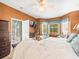 Bright main bedroom featuring a ceiling fan, mounted TV, balcony access, and bay window seating at 7606 Berna Ln, Land O Lakes, FL 34637
