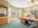 Spacious office with a large wooden desk, ample lighting, and a wall mirror at 7606 Berna Ln, Land O Lakes, FL 34637