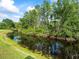 Picturesque water view with lush green landscaping and reflections in the water at 7606 Berna Ln, Land O Lakes, FL 34637