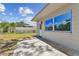Exterior backyard view showcasing the home's siding, a patio, and a well-manicured lawn at 7704 Tanglewood Ln, Tampa, FL 33615