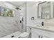 This bathroom features a step-in shower with gray stone-look tiling and sleek black fixtures at 7704 Tanglewood Ln, Tampa, FL 33615