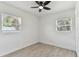 Bright bedroom with a ceiling fan, wood-look floors, and sunny windows at 7704 Tanglewood Ln, Tampa, FL 33615