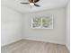 Bright bedroom with a ceiling fan, wood-look floors, and large sunny window at 7704 Tanglewood Ln, Tampa, FL 33615