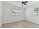 Bright bedroom with white walls, modern ceiling fan, and light wood-look flooring at 7704 Tanglewood Ln, Tampa, FL 33615