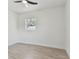 Bright bedroom with a ceiling fan, wood-look floors, and a large sunny window at 7704 Tanglewood Ln, Tampa, FL 33615
