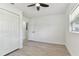 Bright bedroom with a ceiling fan, wood-look floors, and closet with bright white doors at 7704 Tanglewood Ln, Tampa, FL 33615